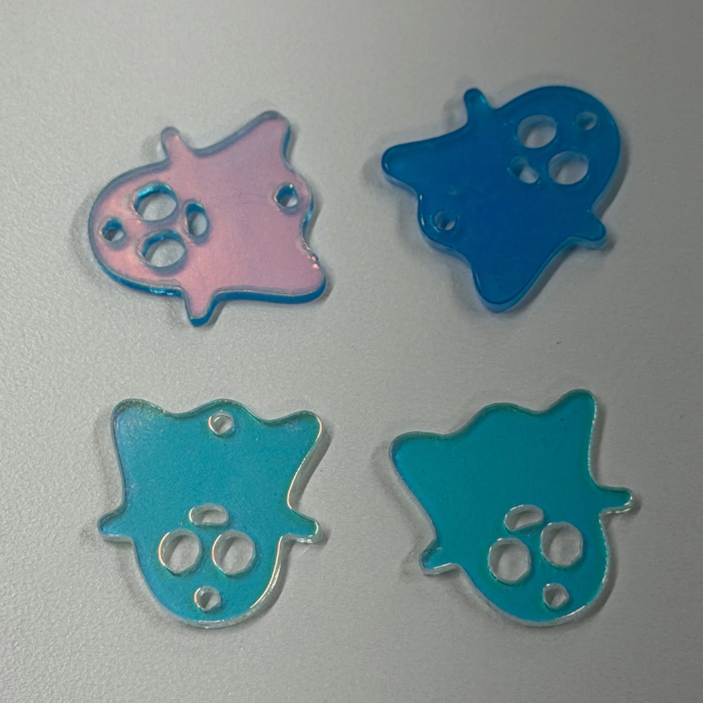 Four blue and pink star-shaped objects on a gray background