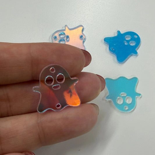 Hand holding a colorful plastic object with two blue star-shaped objects in the background.