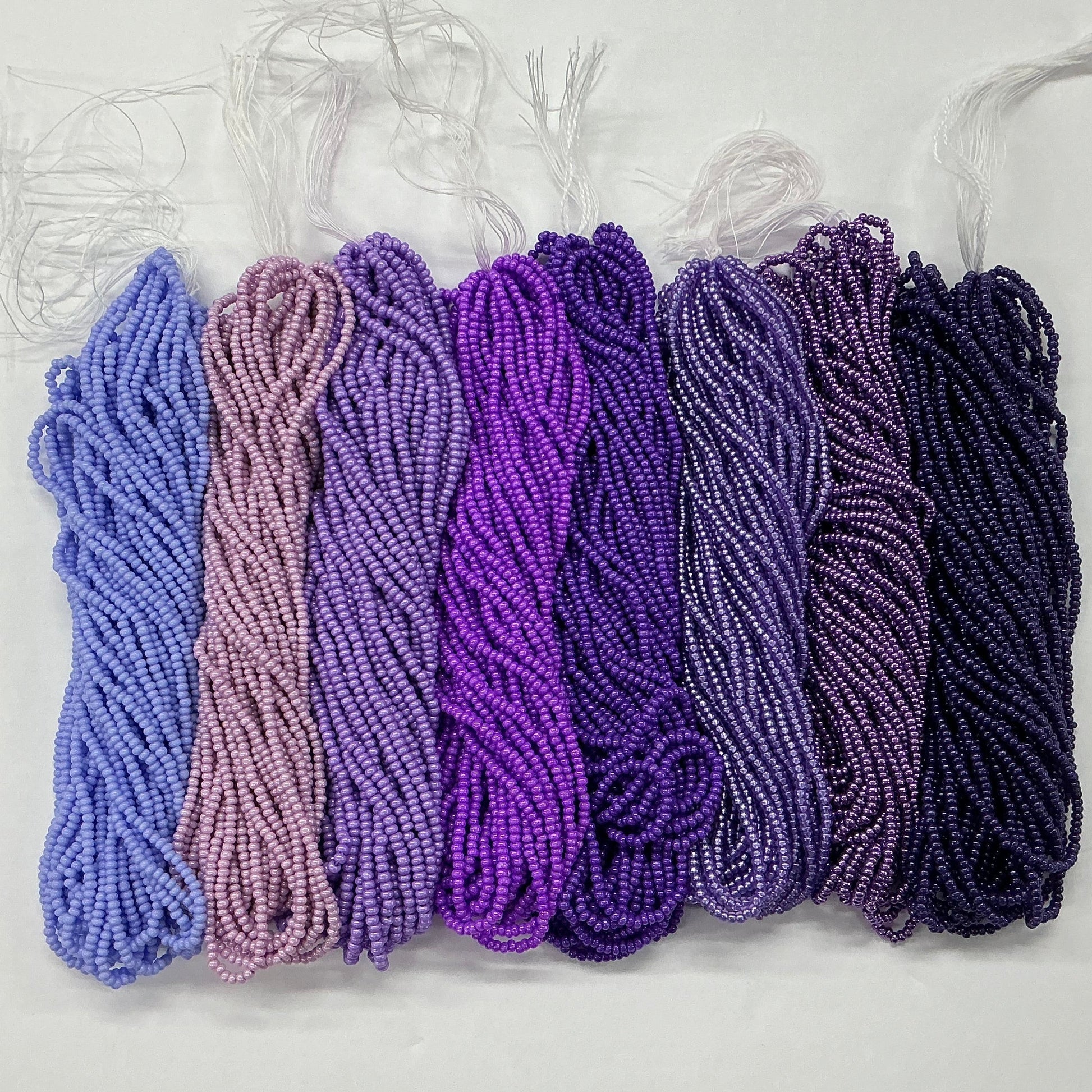 Set of purple and pink yarn skeins on a white background