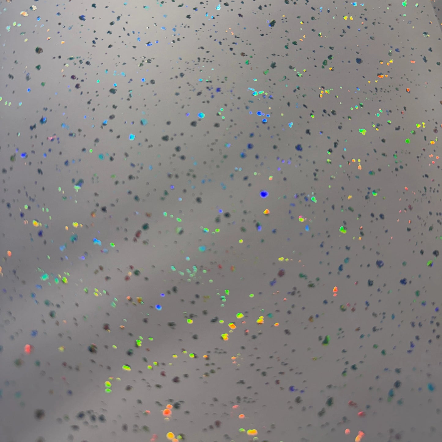 Speckled surface with multicolored dots on a pink background