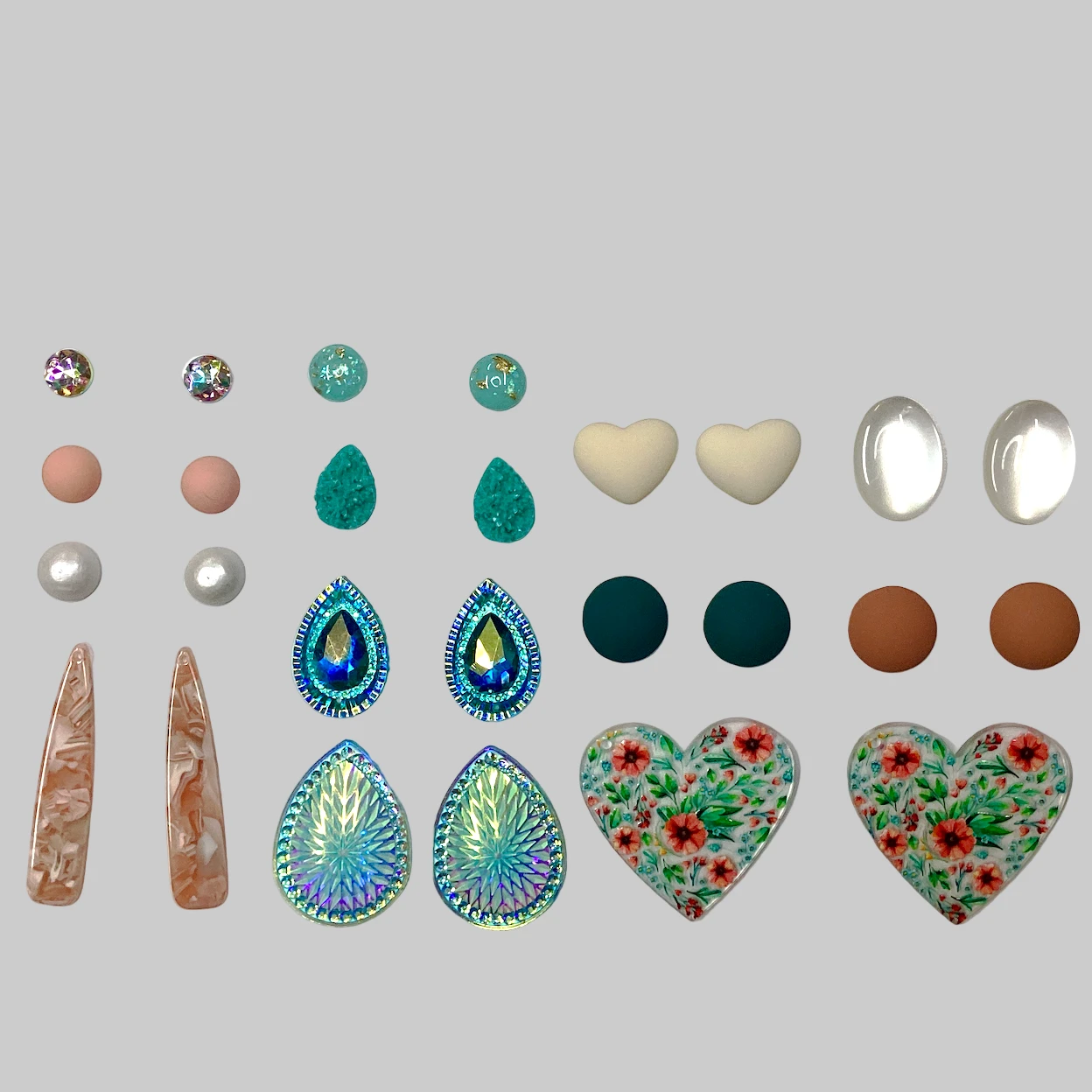 Collection of various jewelry stones and earrings on a white background