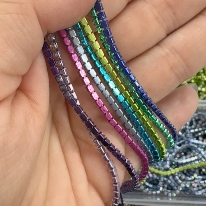 Hand holding colorful beaded bracelets with a blurred background of more beads.